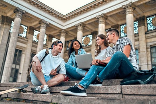 University students sitting together on campus steps during orientation week