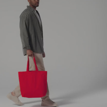 Video of a red organic cotton maxi tote with gusset, carried by hand